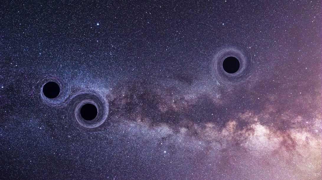 A photo illustration of three black holes on a starry sky background.